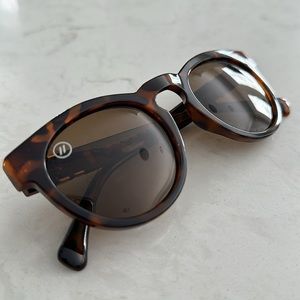 Brown tortoise shell colored sunglasses with gold accents and brown dust bag.